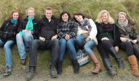 Students on Spring Break in Ireland, sitting side by side on a grassy hill