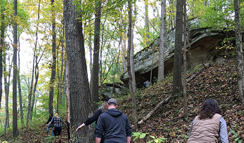 Alumni, students, and guests approaching the Facing Monday Creek Rock Shelter on the Relive the Dig! Field Site Tour