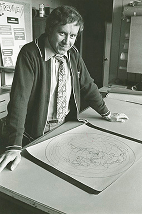 Dr. Hugh Bloemer, standing with a map in an old black and white photo