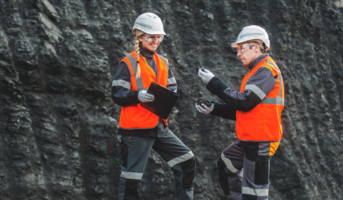 Two speacialists examining coal at an open pit