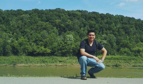 Ricardo Molina Herrera, wins first place in OPIE Writing Contest. shown here kneeling by a lake.