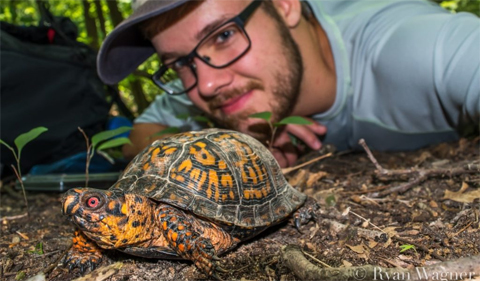 Ryan Wagner takes a selfie with a turtle.