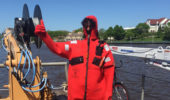 Jack Bruno participates in a day-long safety training session wearing a “dry suit” as he poses on the deck of a NOAA research vessel.